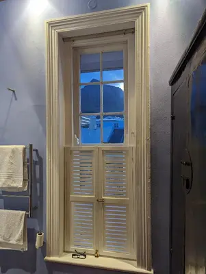 a window with white shutters in a bathroom at La Montagne Observatory in Cape Town