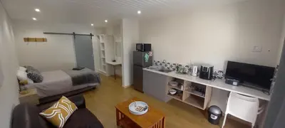 a living room with a bed and a television at Bellville Self Catering in Cape Town