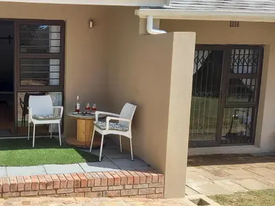 a patio with two chairs and a table on a house at Bellville Self Catering in Cape Town