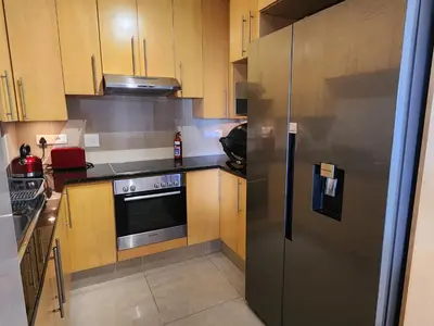 a kitchen with a stainless steel refrigerator and wooden cabinets at Hibernian Towers 1203 in Strand
