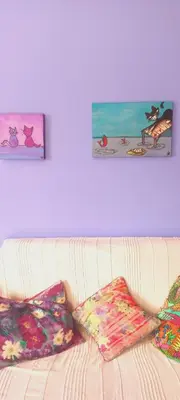 a white couch with two pillows on top of it at Cat Nap Cottage in Bettyʼs Bay