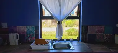a kitchen with a sink and a window at Cat Nap Cottage in Bettyʼs Bay
