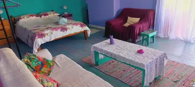 a living room with a bed and a couch and a table at Cat Nap Cottage in Bettyʼs Bay