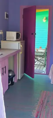 a room with a colorful room with a table and a door at Cat Nap Cottage in Bettyʼs Bay