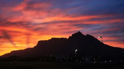 a sunset with a mountain in the background at Loft with views in Cape Town