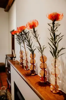 four vases with flowers in them on a table at Die Stal at Antioch in Franschhoek