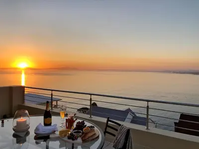 a table with food and a bottle of wine on a cruise ship at Bayview in Gordonʼs Bay