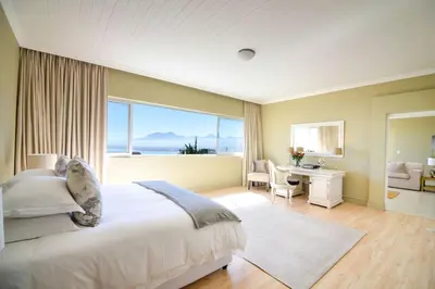 a bedroom with a large bed and a large window at Bayview in Gordonʼs Bay