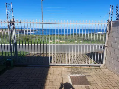 a gate with a view of the ocean at The Waves of Schulphoek in Hermanus