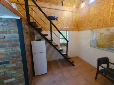 a staircase in a room with a refrigerator and a brick wall at The Red Fox in Cape Town