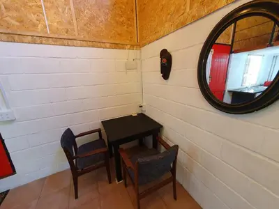 a small table and chairs in a room with a mirror at The Red Fox in Cape Town
