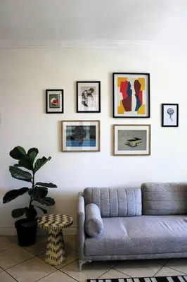 a living room with a couch and pictures on the wall at Contemporary Central Apartment by ARPA Hospitalities in Stellenbosch