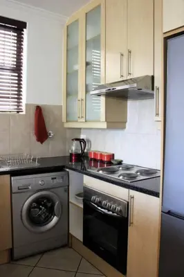 a kitchen with a washer and a stove and a dishwasher at Contemporary Central Apartment by ARPA Hospitalities in Stellenbosch