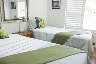 a bedroom with two beds and a mirror at Garten Wohnung mit Pool, 2 Schlafzimmer in Cape Town