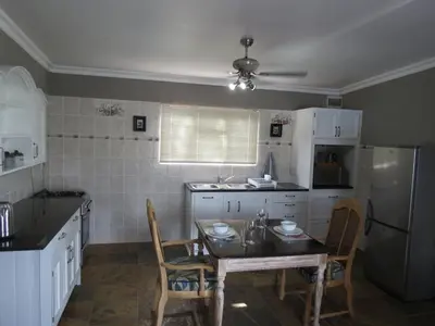 a kitchen with a table and chairs and a refrigerator at 10 on Berg in Villiersdorp
