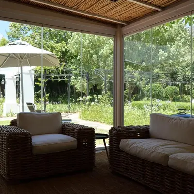 a screened porch with two chairs and an umbrella at Kleinhof in Franschhoek
