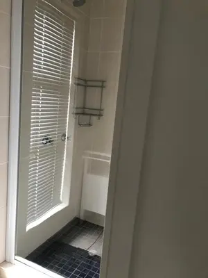 a bathroom with a tub and a shower with a window at Vue La Mer in Hermanus