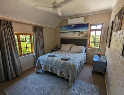 a bedroom with a bed and two windows at 33 Longifolia in Stellenbosch