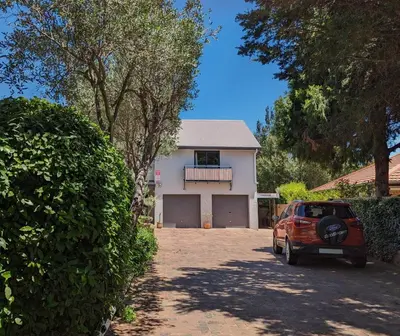 a car parked in front of a white house at 33 Longifolia in Stellenbosch