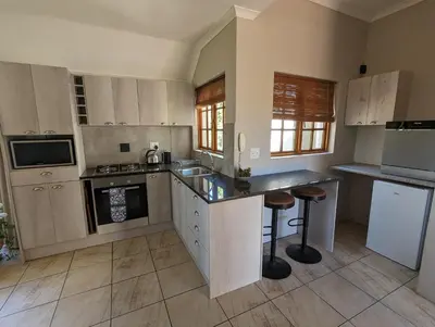 a kitchen with white cabinets and a counter top at 33 Longifolia in Stellenbosch