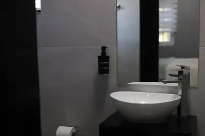 a bathroom with a white sink and a mirror at Trendy Cottage Hideaway in Cape Town