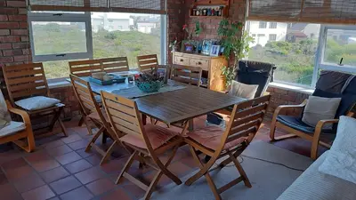 a dining room with a wooden table and chairs at Betty's Bay Holiday home in Clareport