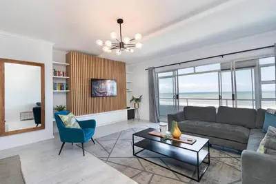 a living room with a couch and a table at Searenity Sands in Strand