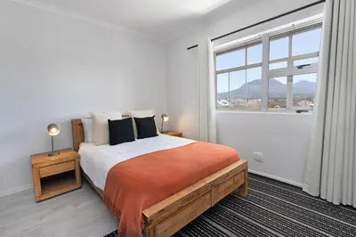 a bedroom with a large bed and a large window at Searenity Sands in Strand