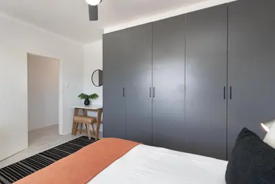 a bedroom with gray cabinets and a bed at Searenity Sands in Strand
