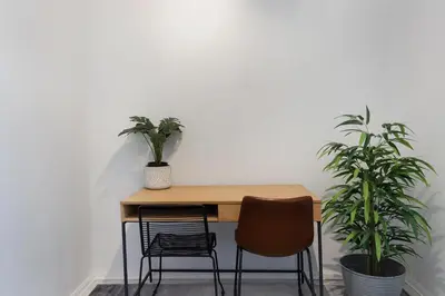 a wooden table with two chairs and two plants at Searenity Sands in Strand