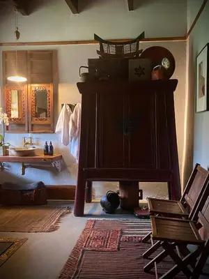 a living room with a clock on a cabinet and a table at De Dapper Huys in Philadelphia