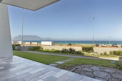 a patio with a view of the ocean at Sea Spray AG04 in Bloubergstrand
