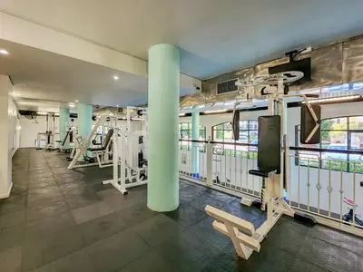 a gym with rows of treadmills and machines at Pool, Gym, self check-in,Parking in Cape Town