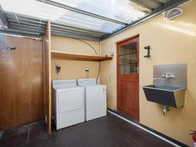 a laundry room with a sink and a washing machine at Dai Heka Guest House in Strand