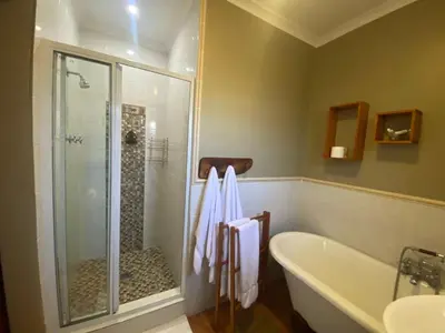 a bathroom with a shower and a bath tub at Dai Heka Guest House in Strand