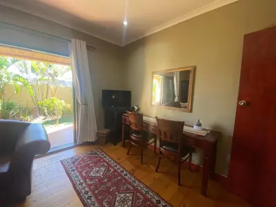 a living room with a table and chairs and a mirror at Dai Heka Guest House in Strand