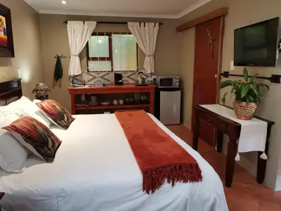 a bedroom with a large white bed and a sink at Dai Heka Guest House in Strand