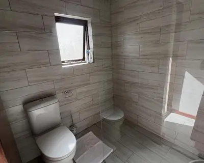 a bathroom with a toilet and a window at Kabana Family Home and Guest House in Cape Town