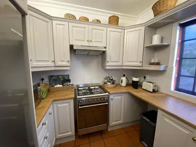 a kitchen with white cabinets and a stove top oven at Barford Haven in Hermanus