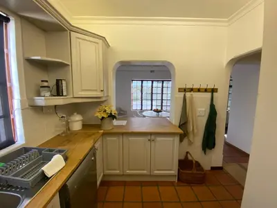 a kitchen with white cabinets and a window at Barford Haven in Hermanus