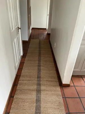 a hallway with a rug on the floor next to a door at Barford Haven in Hermanus