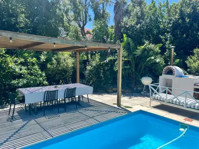 a patio with a table and chairs next to a pool at Morningside Studio apartment, load shedding proof in Cape Town
