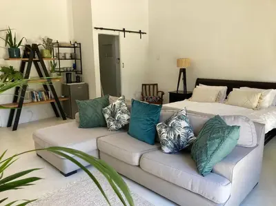 a living room with a couch with pillows on it at Morningside Studio apartment, load shedding proof in Cape Town