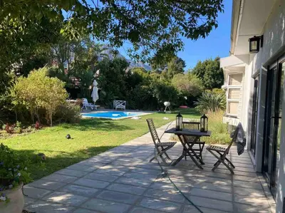 a patio with a table and chairs next to a house at Morningside Studio apartment, load shedding proof in Cape Town