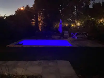 a swimming pool at night with a blue illumination at Morningside Studio apartment, load shedding proof in Cape Town