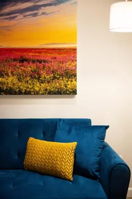 a blue couch with a painting of a field of flowers at 505 La Roche, Paarl in Paarl