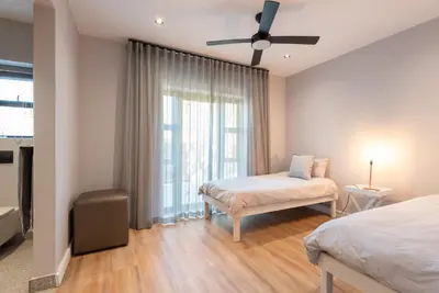a bedroom with two beds and a window at Villa Paradys - Serviced in Stellenbosch