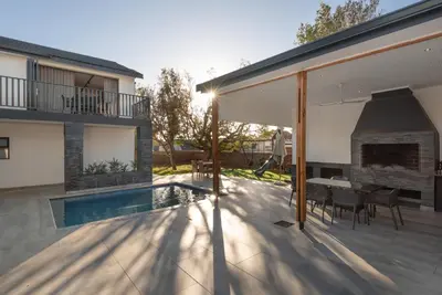 a patio with a fireplace next to a house at Villa Paradys - Serviced in Stellenbosch
