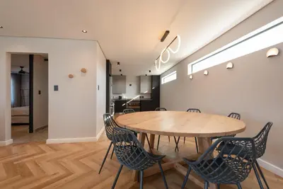 a dining room with a wooden table and chairs at Villa Paradys - Serviced in Stellenbosch