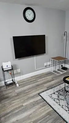 a living room with a flat screen tv on a wall at SS Luxury Apartments in Cape Town
